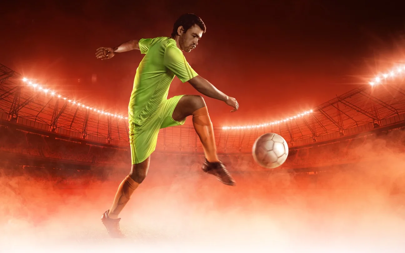 Imagem de divulgação de jogador chutando bola de futebol em estádio.