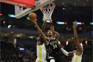 Astro dos Bucks, Antetokounmpo vai para cima da marcação do Warriors, em dezembro/2022, em partida válida pela temporada regular da NBA (Stacy Revere/Getty Images)