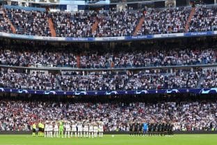 Los aficionados del Real Madrid asisten al partido de La Liga en el estadio Santiago Bernabeu