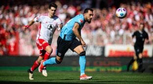 Jogador do Bayer Leverkusen disputa bolo com atleta do Union Berlin