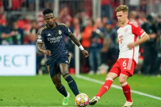 Kimmich disputa bola contra Vinícius Júnior em jogo entre Real Madrid e Bayern de Munique pela Champions