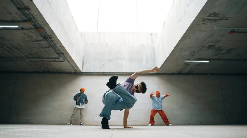 Grupo de hipster elegante se apresentam break dance juntos no edifício.