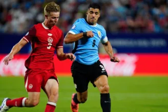 Suárez, do Uruguai, disputa bola com jogador do Canadá