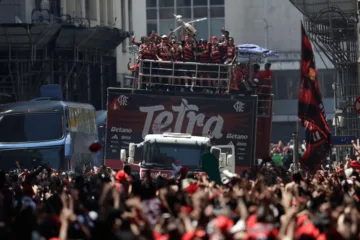 Jogadores do Flamengo, no trio elétrico, levantam a taça, para uma multidão de torcedores